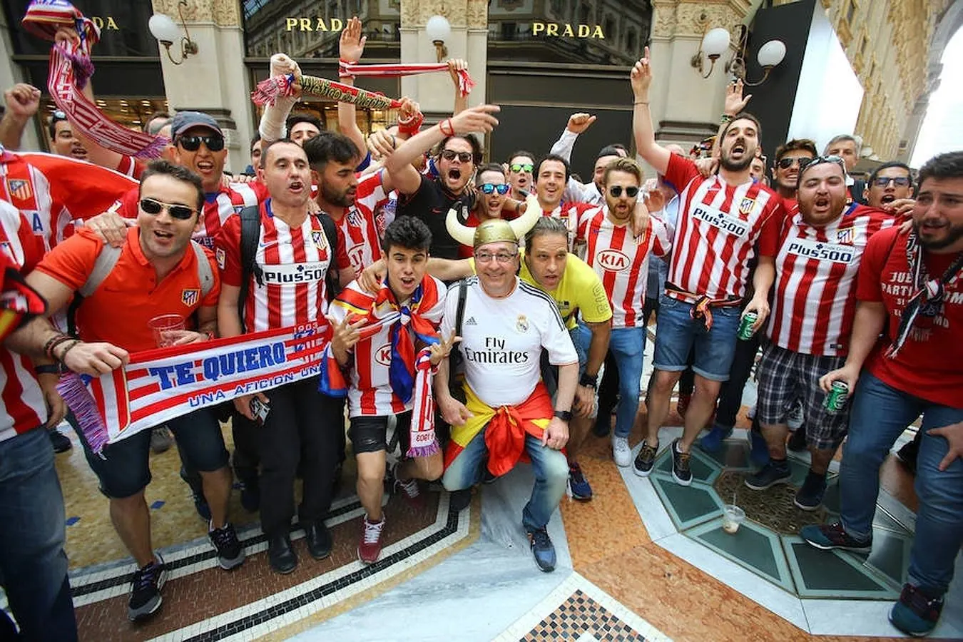 Seguidores del Atlético se hacen una foto junto a un aficionado del Real Madrid. 