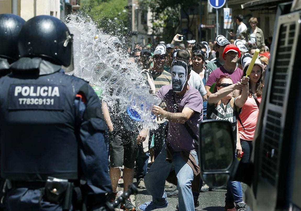 Manifestantes se enfrentan a los antidisturbios de los Mossos d'Esquadra, durante los incidentes producidos esta mañana en el barrio de Gràcia de Barcelona. 
