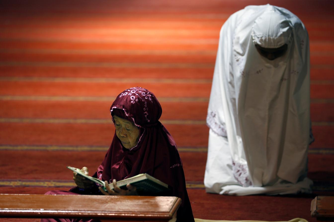 Una mujer musulmana lee el corán en el primer día del Ramadán en una mezquita de Yakarta