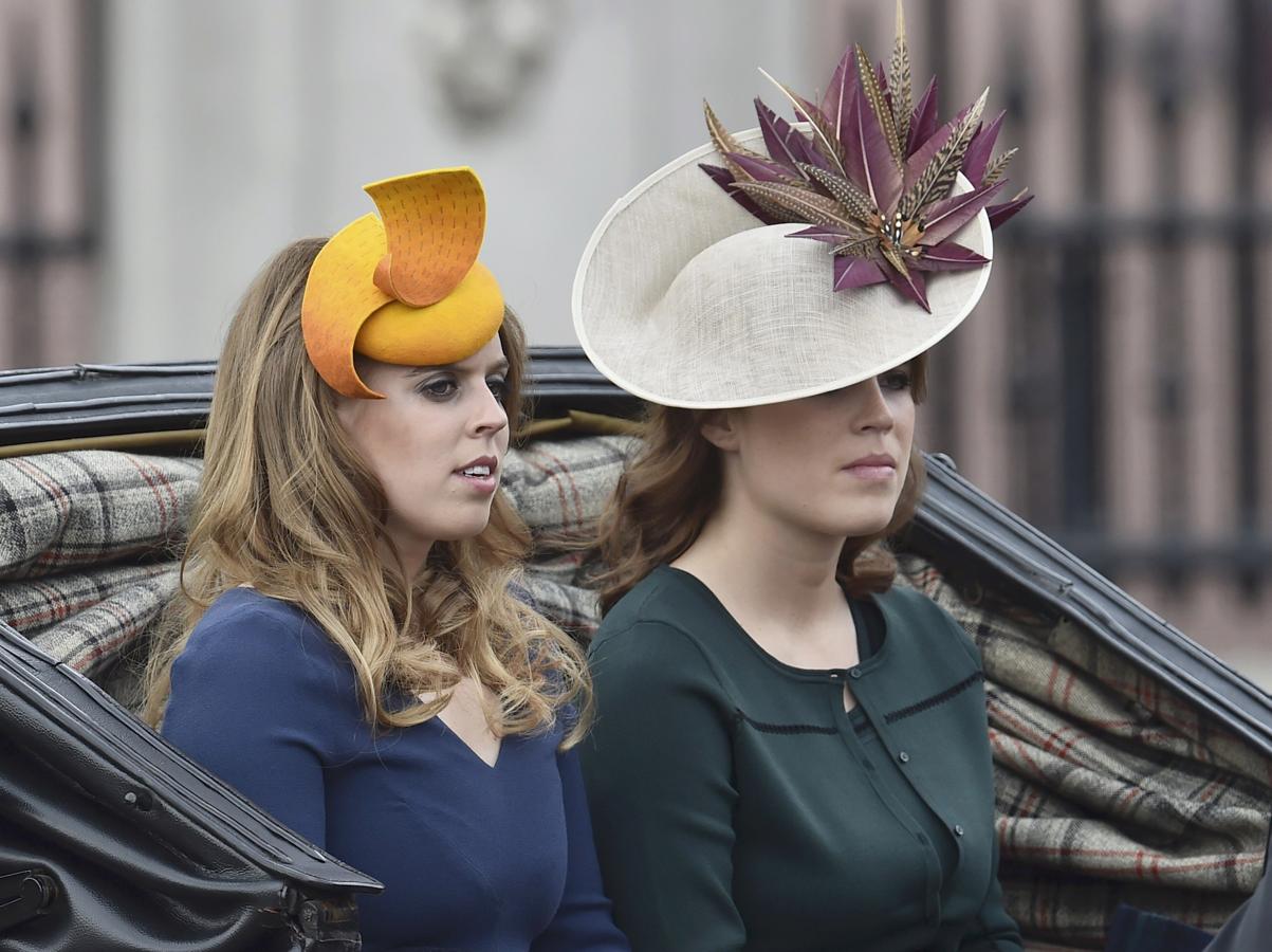 La princesas Eugenia y Beatriz de York  han optado por prendas de colores vivos, con sombreros de naranja y plumas moradas. 