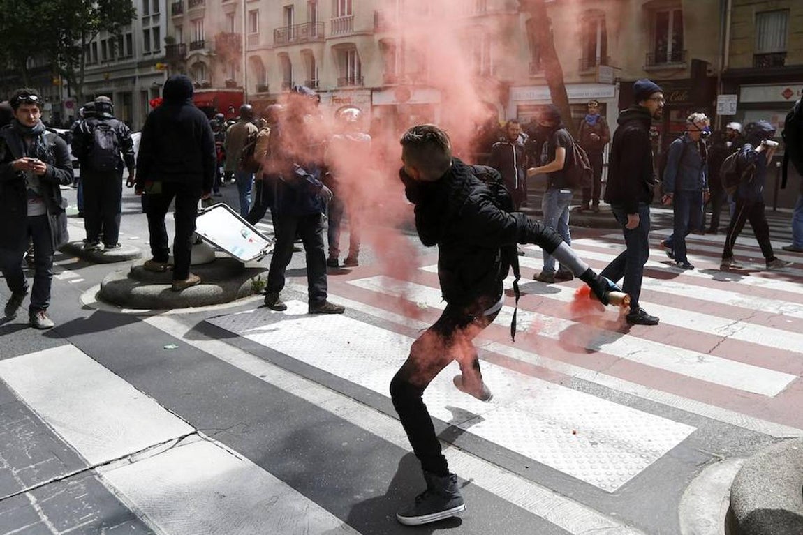 Un manifestante se dispone a lanzar un dispositivo contra los antidisturbios. 