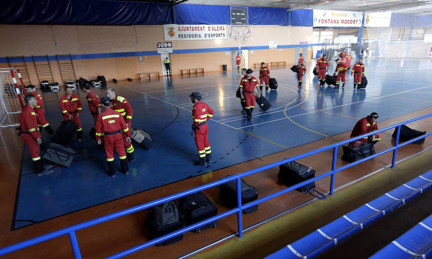 Miembros de la Unidad Militar de Emergencias descargan su equipo en el polideportivo de Alzira