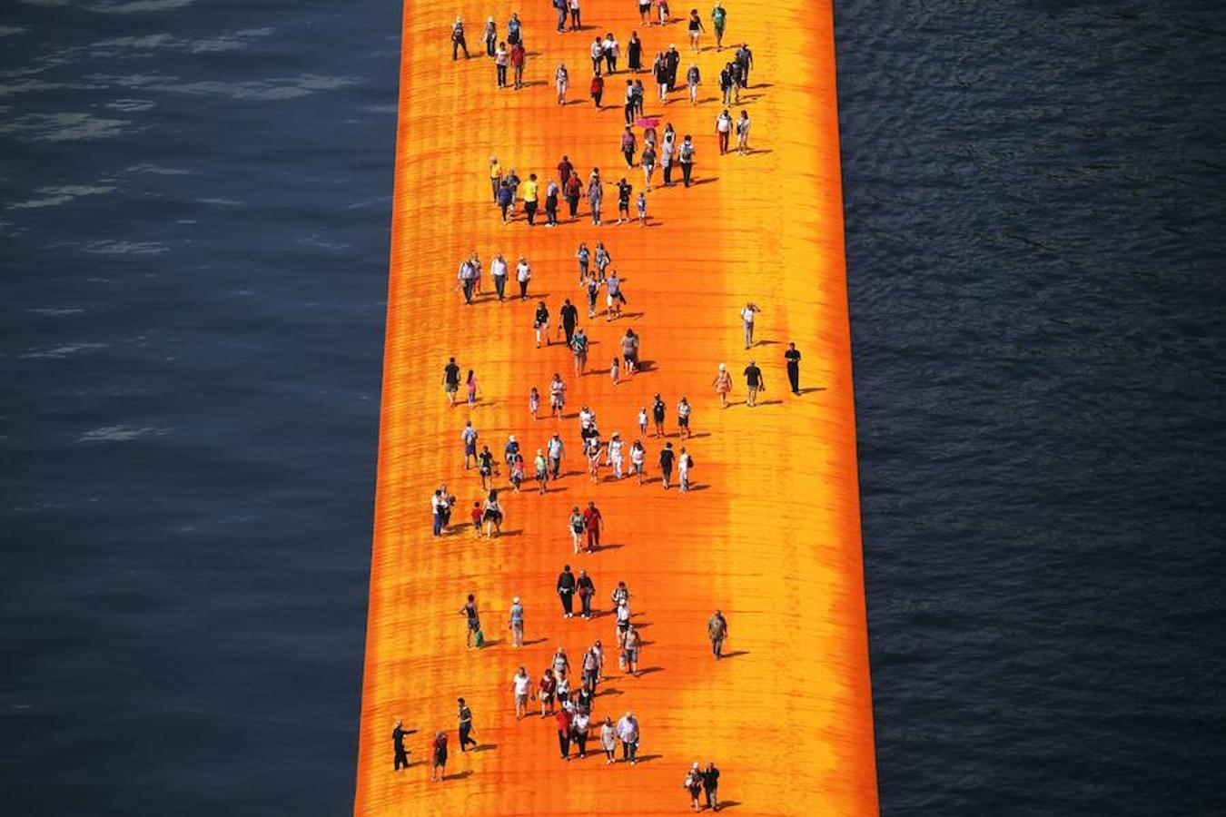 Primeros visitantes. La gente andando por el puente creado por Christo Vladimirov Javacheff en la isla de Iseo