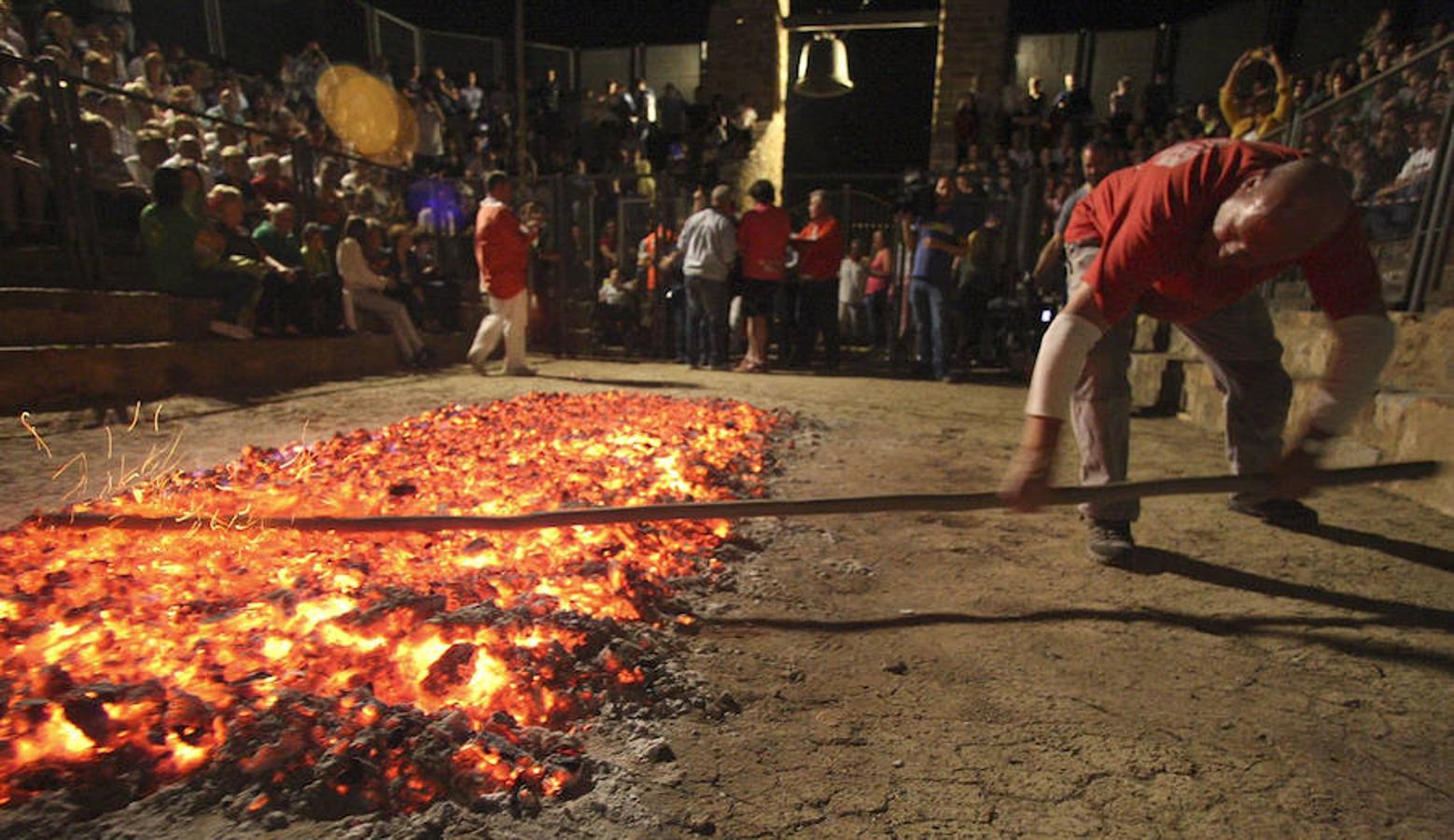 Un momento de la preparación de las brasas colocadas en el anfiteatro de la ermita de la Peña, en el pueblo soriano de San Pedro Marique. 