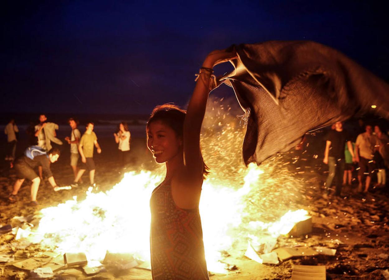 Una joven disfruta junto a una hoguera, hoy en la playa de La Zurriola de San Sebastián. 