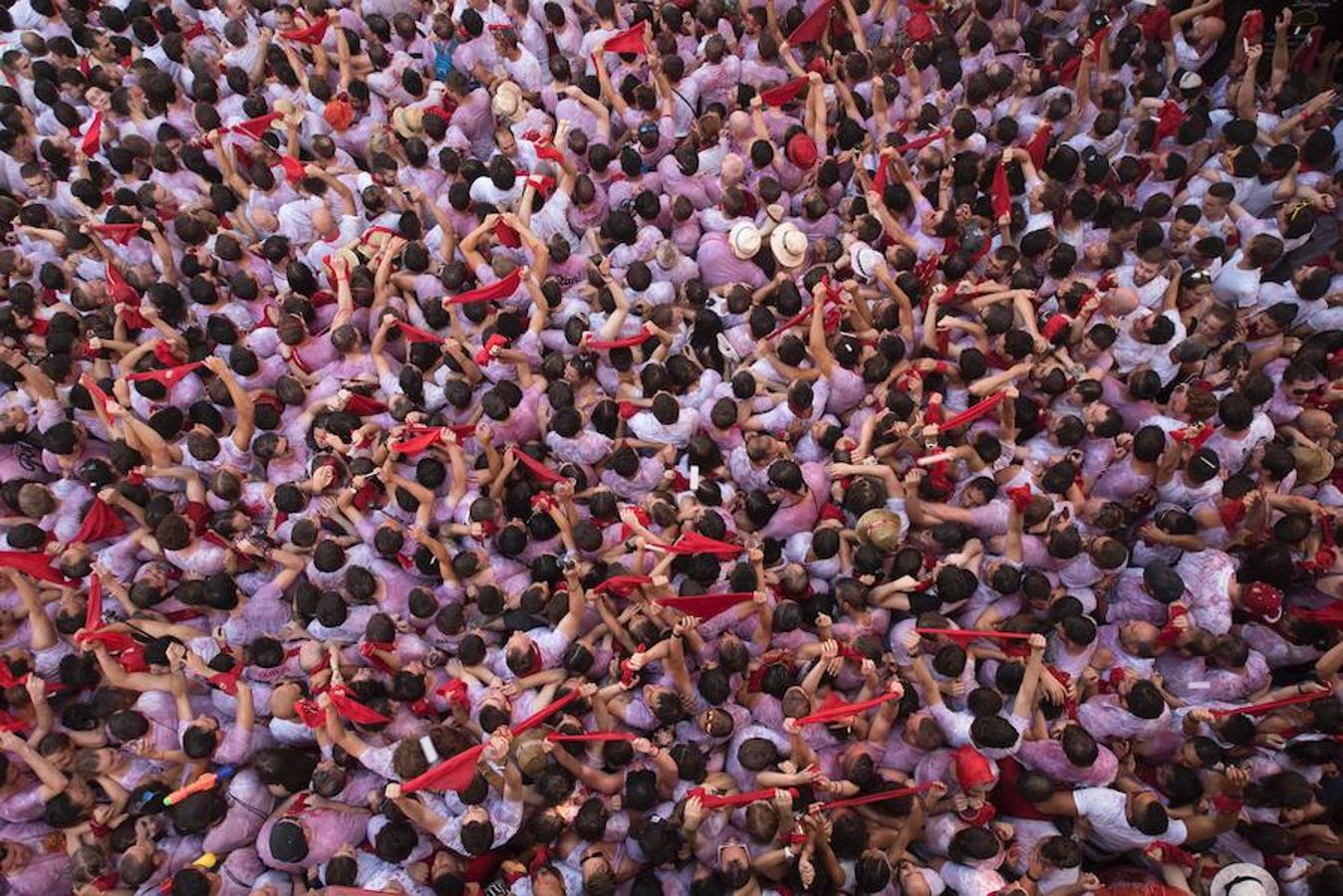 La capital navarra se llena de personas de blanco con el tradicional pañuelo rojo atado al cuello. 