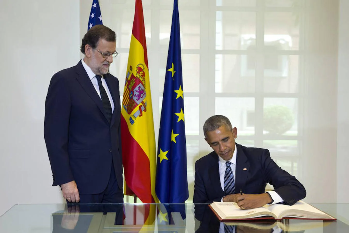 El presidente de los EEUU, Barack Obama (d), firma en el libro de honor, ante la mirada del presidente del Gobierno, Mariano Rajoy (i)
