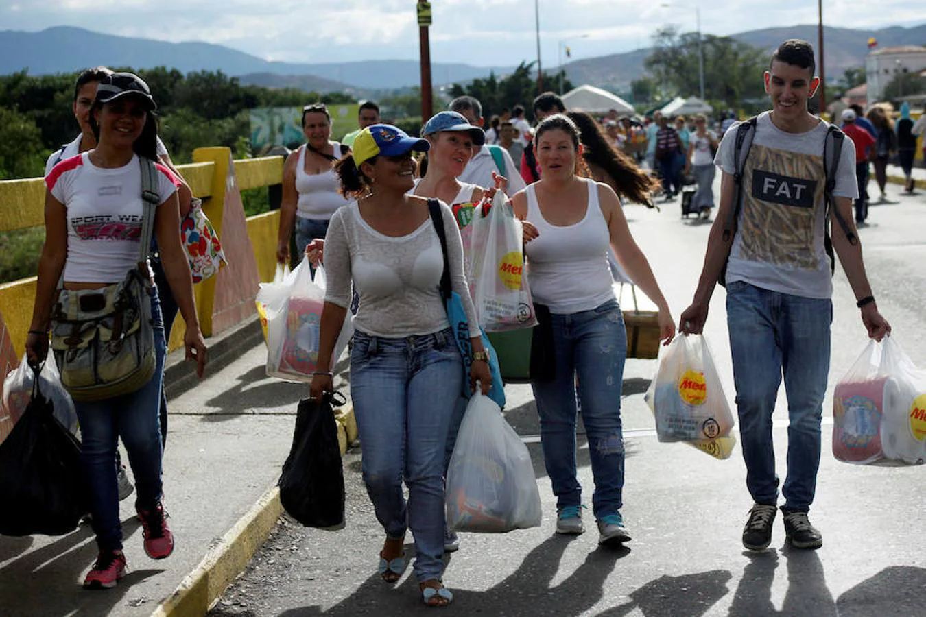 Varias mujeres sonríen a su vuelta a Venezuela con las bolsas cargadas de productos básicos. 