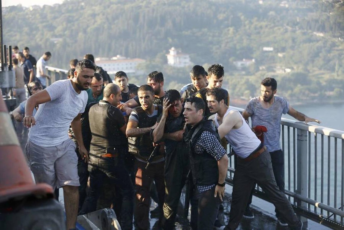La policía protege de la multitud a un golpista antes de ser detenido. 
