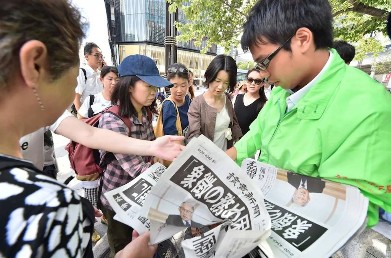 Un repartidor de periódicos de Tokio, con la edición especial tras el discurso del Emperador Akihito de este lunes