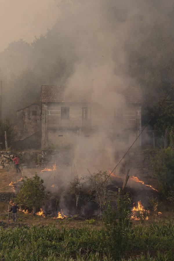 Fuego con una vivienda de fondo, en Soutomaior. 