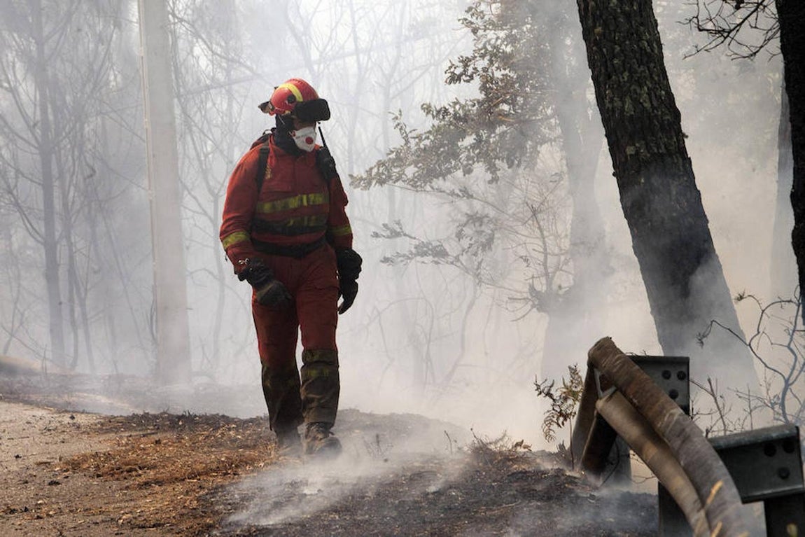 Un efectivo de la UME pasa ante una zona quemada por el incendio forestal de Arbo. 