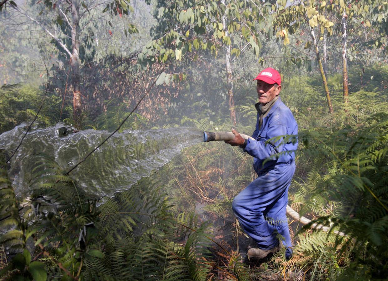 Un vecino de O Roxido participa en las tareas de extinción del incendio que se inició en San Juan de Fecha (Galicia). 