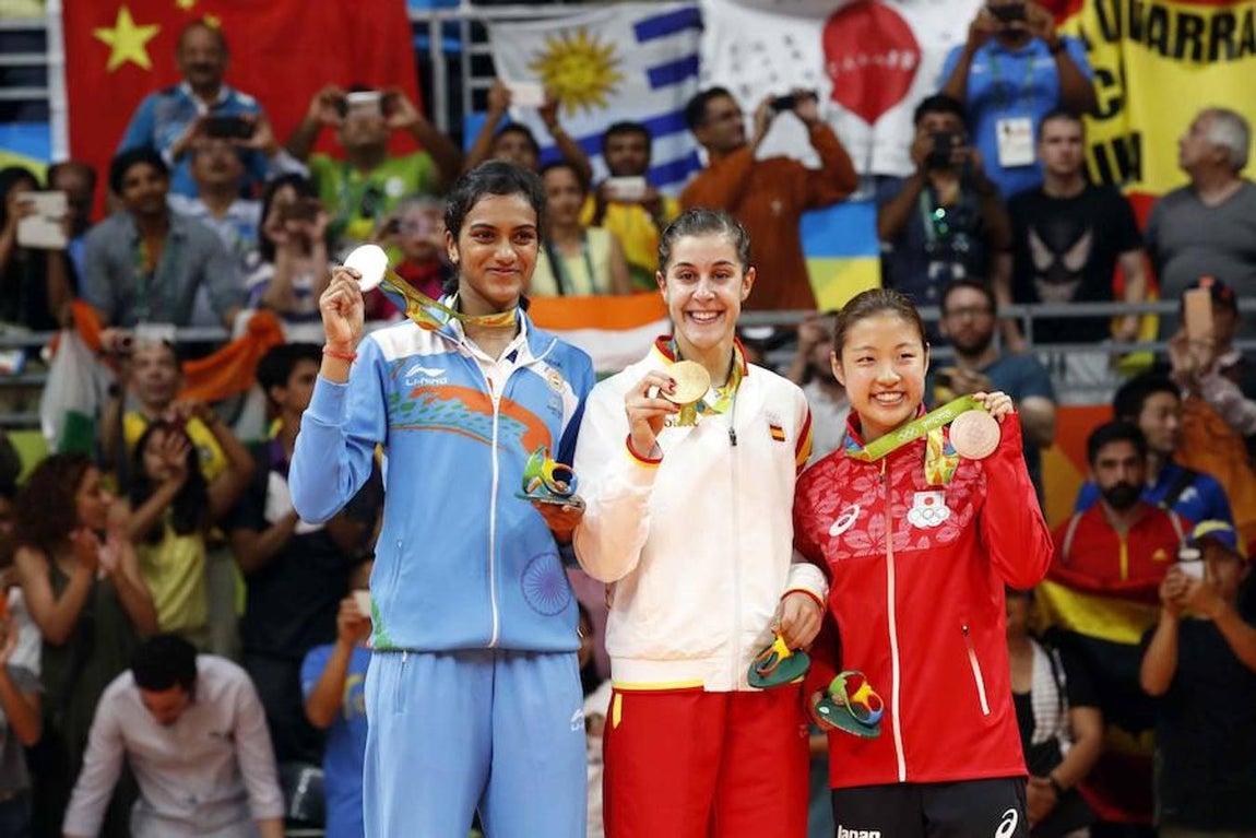 Las tres ganadoras sostienen sus medallas. 