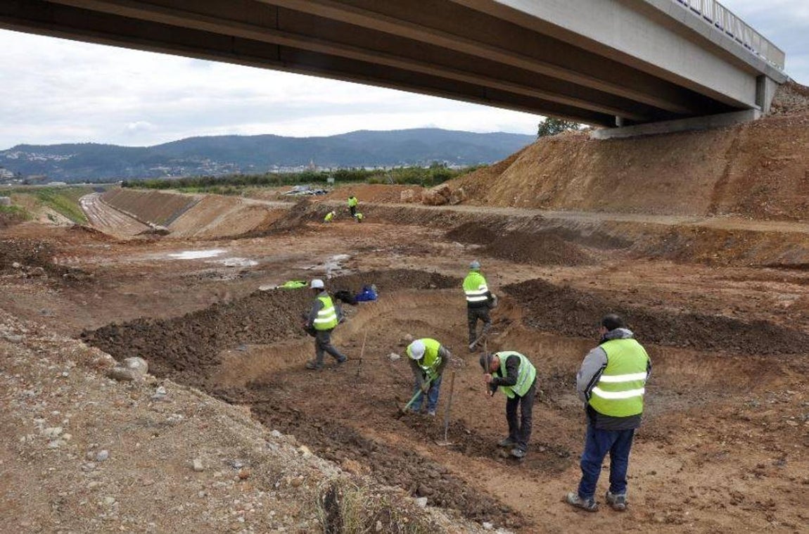 Equipo de arqueología excavando a mano. 