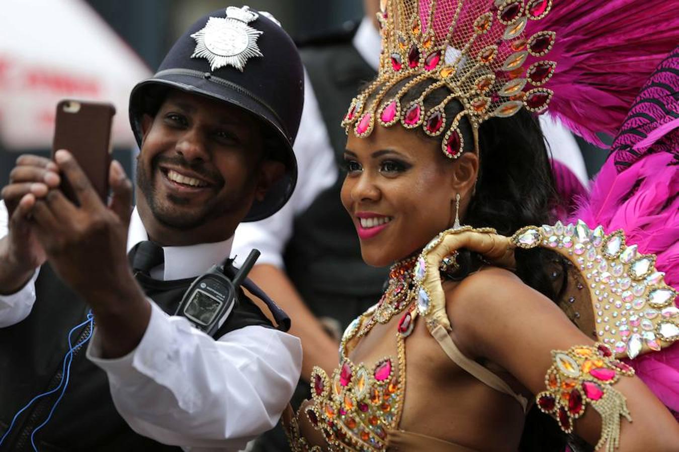 Un policía se hace una foto con una de las participantes del desfile. 