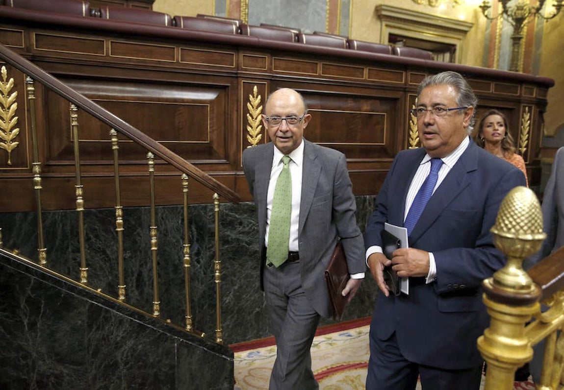 El ministro de Hacienda en funciones, Cristóbal Montoro,iz., acompañado por el diputado popular Juan Antonio Juan Antonio Zoido, a su llegada al hemicíclo del Congreso de los Diputados. 
