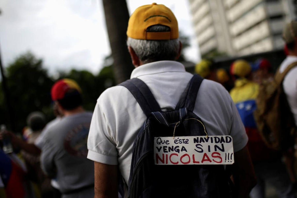 Un manifestante de la marcha porta un cartel en el que se lee: «que está navidad venga sin Nicolás». 