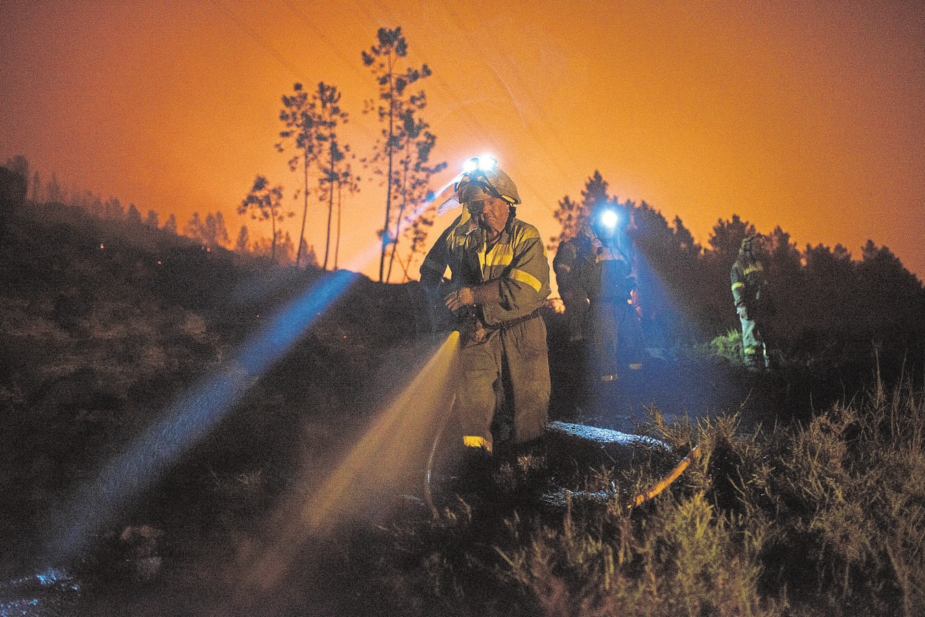 Varios brigadistas realizan trabajos extinción en el incendio forestal declarado en la localidad orensana de Entrimo