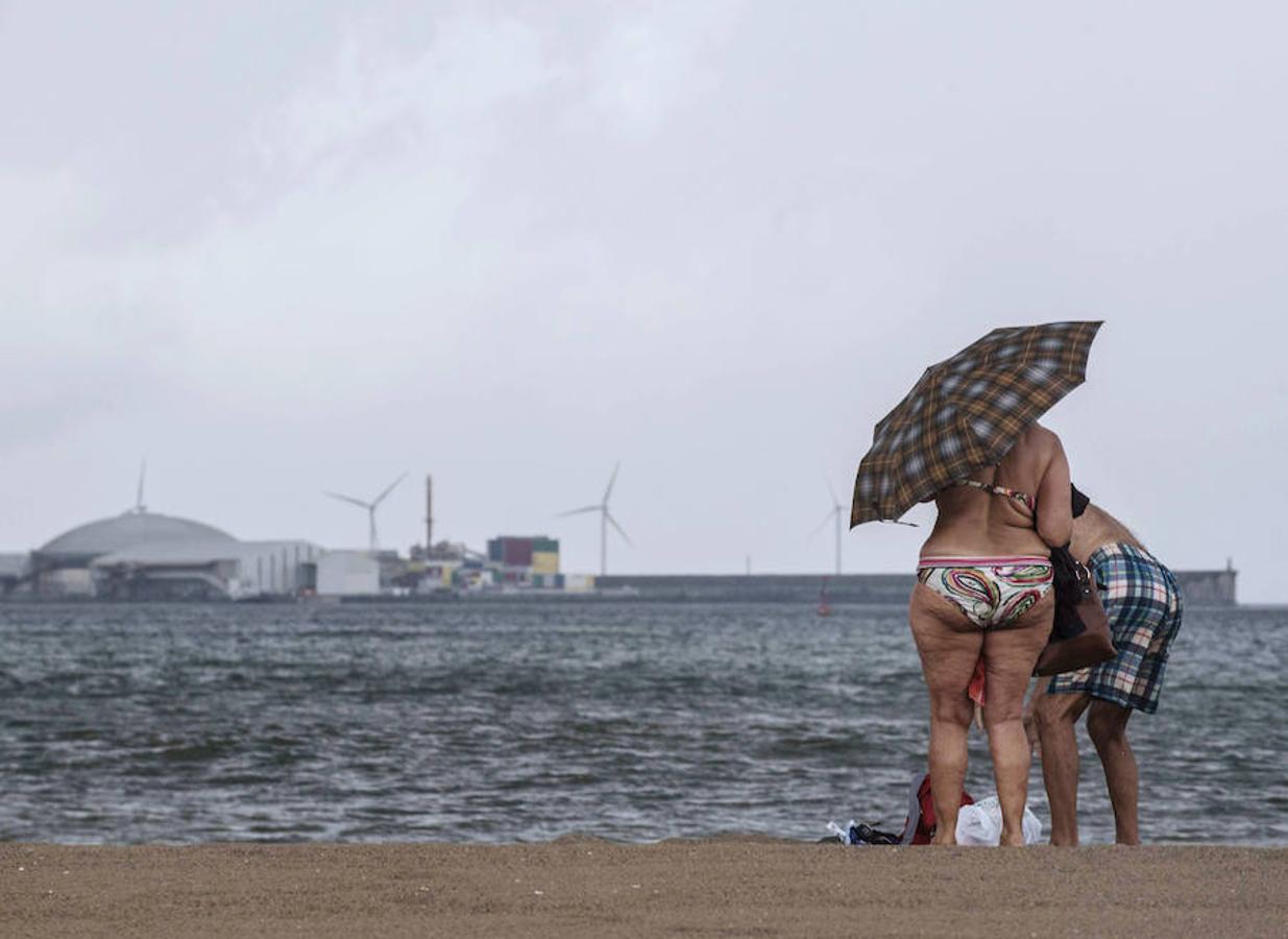 Bilbao. Un matrimonio abandona la playa de Ereaga en Getxo bajo un paraguas tras verse sorprendidos por la fuerte lluvia, después de que ayer se registrara en Bilbao la temperatura más alta desde 1988 (39 grados)