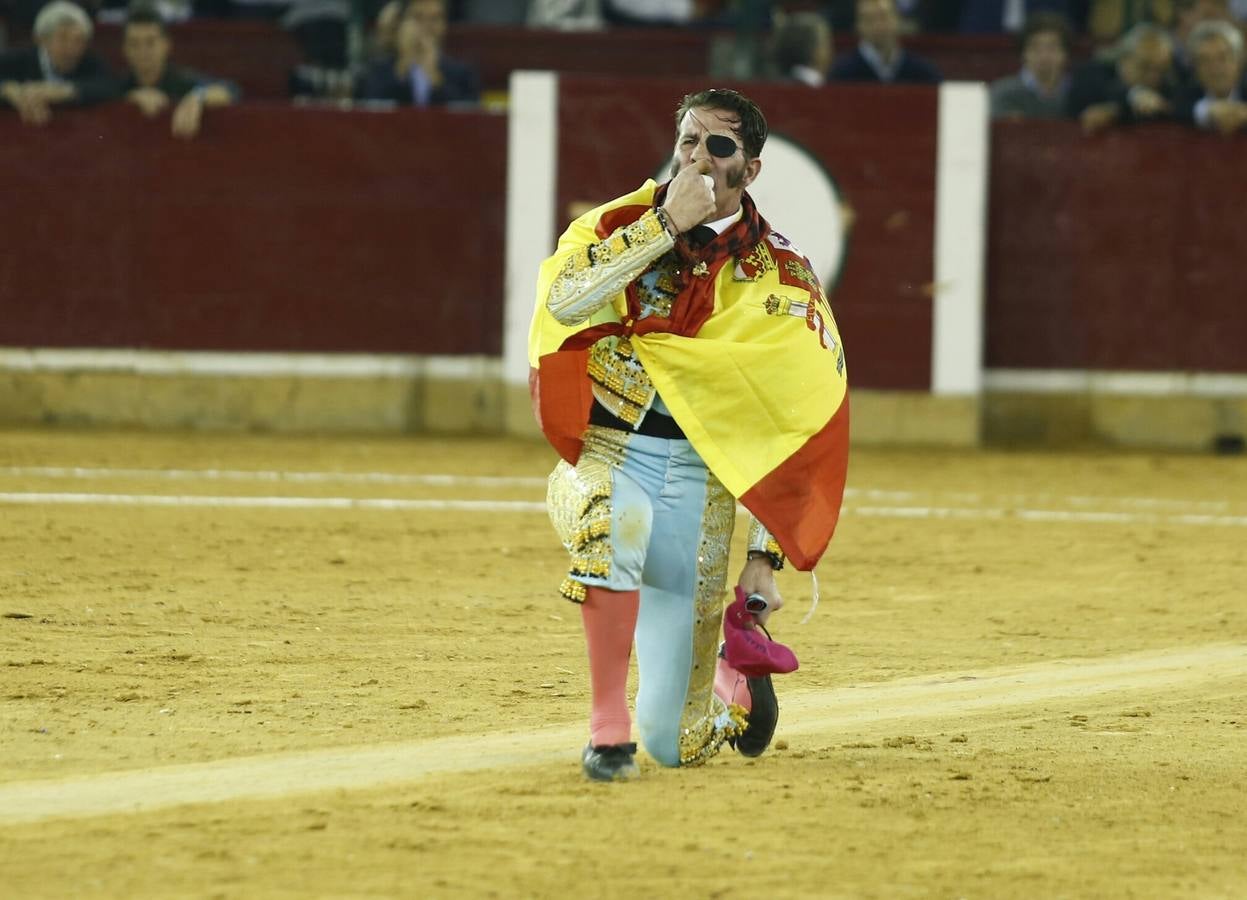 Padilla, envuelto en la bandera de España, besa la arena del coso maño. 