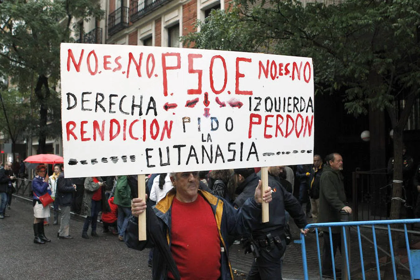 Un hombre porta una pancarta ante la sede del PSOE donde se ha celebrado la decisiva reunión de su Comité Federal.
