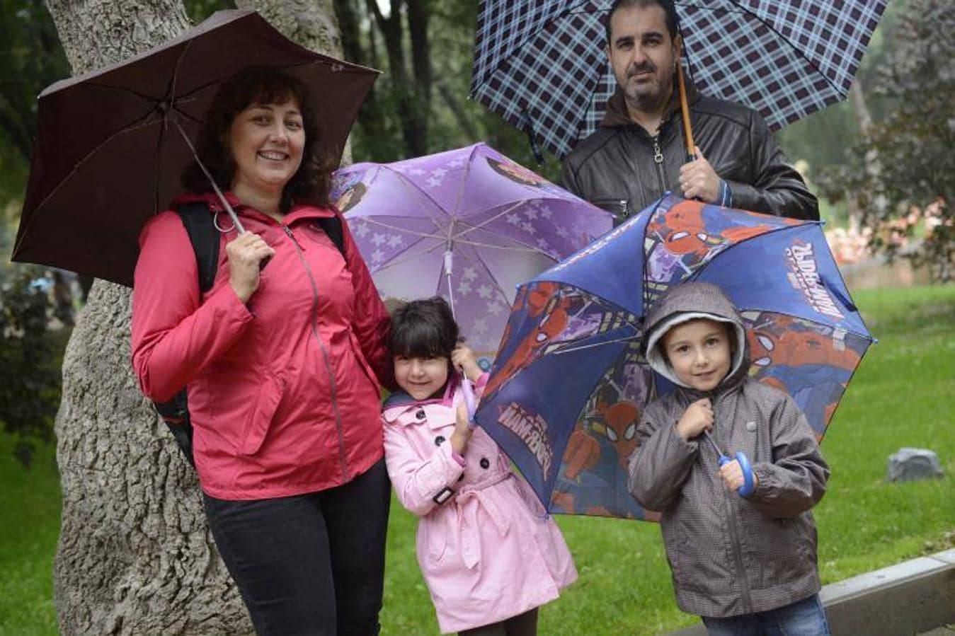 Una familia disfutando del zoo bak¡jo la lluvia