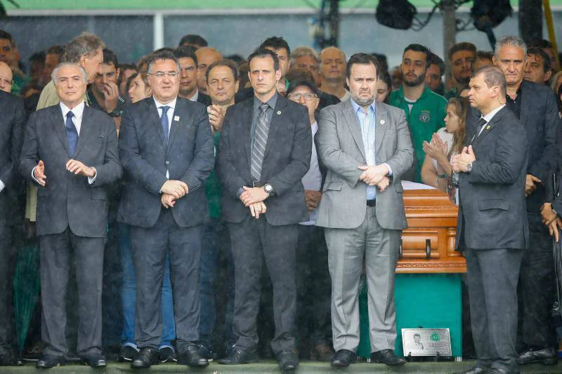 El presidente Michel Temer (i) y el entrenador de la selección brasileña Tite (d) son vistos junto a féretros de los jugadores y equipo técnico del club brasileño Chapecoense durante el velorio colectivo de las víctimas