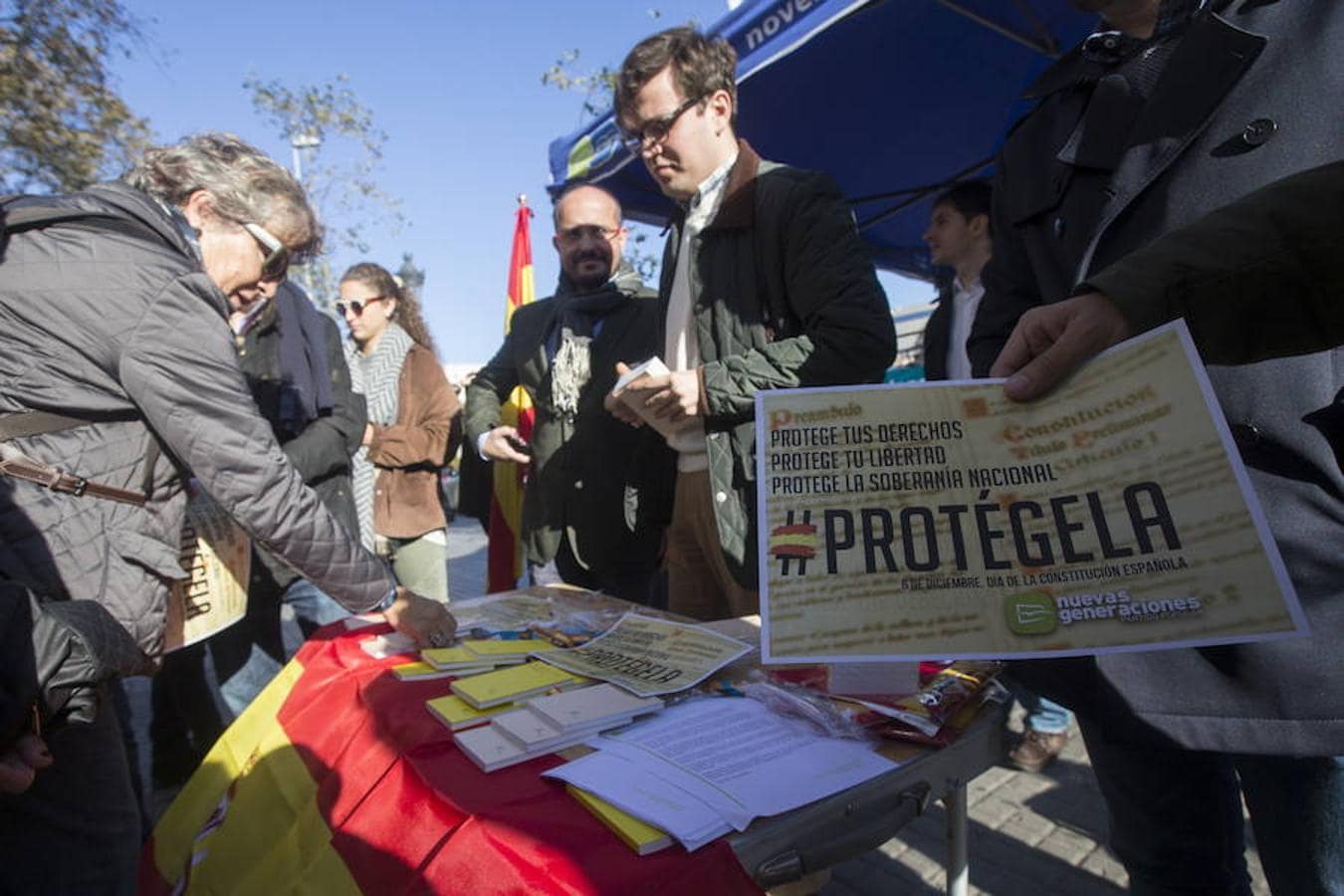 Las Nuevas Generaciones del PPC reparten ejemplares de la Carta Magna, pulseras y banderas de España coincidiendo con el Día de la Constitución