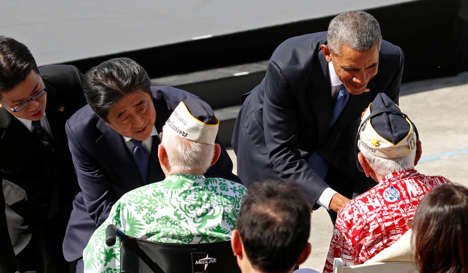 El presidente de Estados Unidos, Barack Obama, junto al primer ministro de Japón, Shinzo Abe, saludan a tres veteranos en el Memorial USS Arizona de Pearl Harbor. 