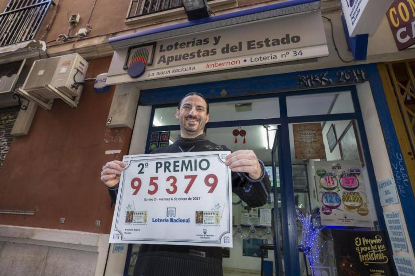 El gerente de la administración de loterias La Bruja Rockera, la número 34 de Murcia, José María Imbernon, muestra el cartel del segundo premio del sorteo del Niño, el 95.379. 