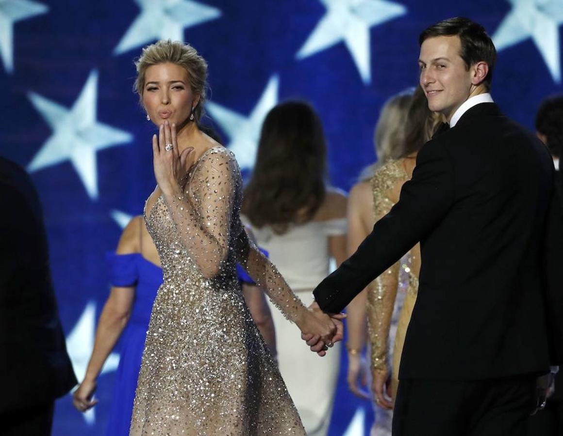 La hija del presidente, Ivanka Trump, lanza un beso acompañada de su marido, Jared Kushne, en el baile inaugural.. 