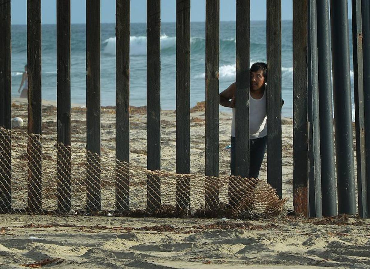 Un hombre mira a través de la verja que separa México y Estados Unidos en San Diego