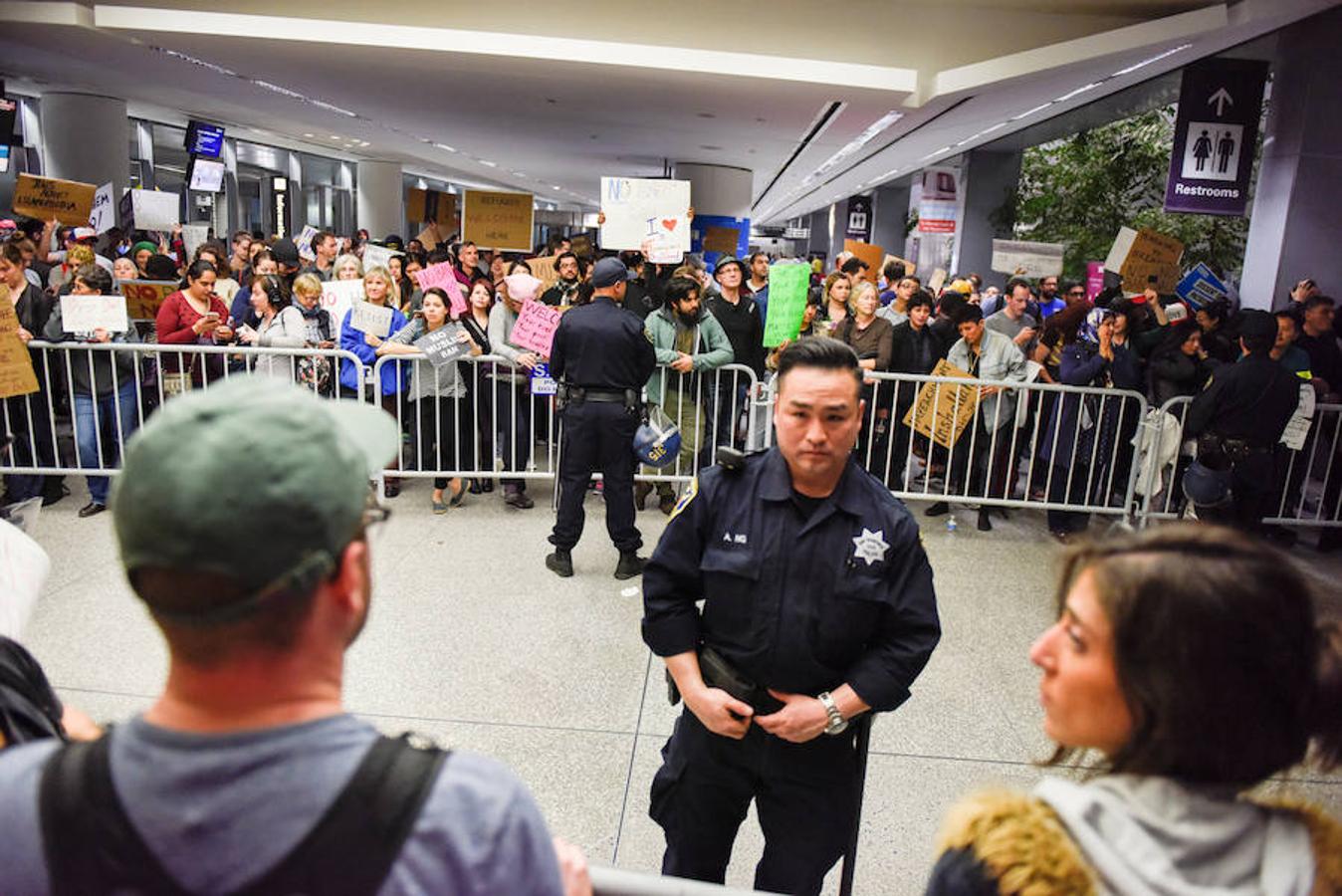 Un cordón policial vigila a los protestantes en el aeropuerto de San Francisco, este lunes. 