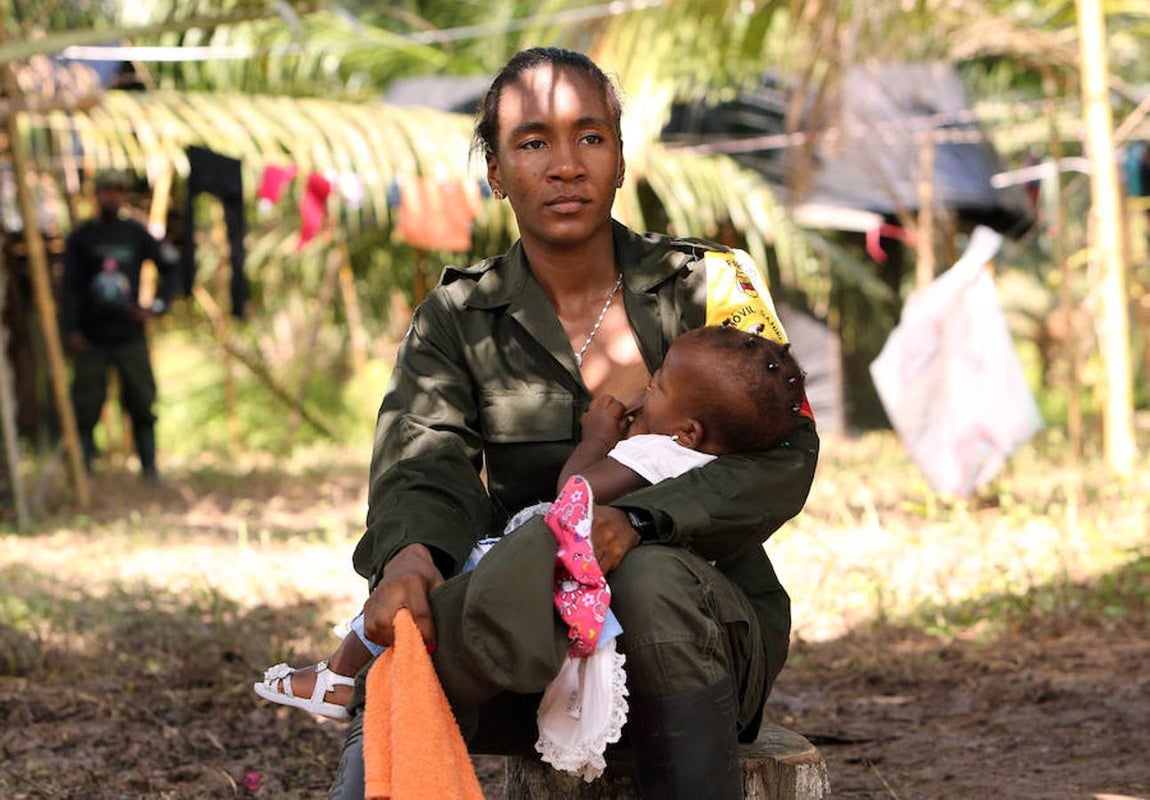 Una mujer de la guerrilla de las Fuerzas Armadas Revolucionarias de Colombia (FARC) amamanta a su bebe en un zona veredal en La Variante, municipio de Tumaco. 