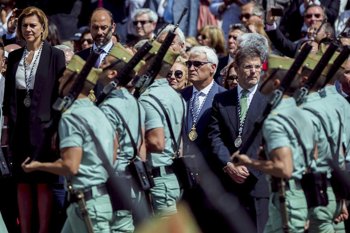 Los ministros de Defensa, María Dolores de Cospedal (i), y de Justicia, Rafael Catalá (d), entre otros representantes políticos y autoridades, durante el desfile de los legionarios del Tercio «D. Juan de Austria», III de La Legión, tras el traslado del Santísimo Cristo de la Buena Muerte y Ánimas «Cristo de Mena». 