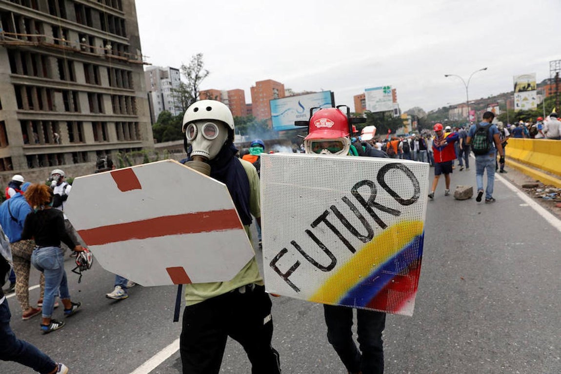 Los partidarios de la oposición se enfrentan a los antidisturbios. Los partidarios de la posición se pelean con la policía antidisturbios llevando un escudos caseros