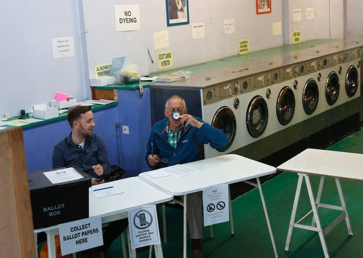 Votación en una lavandería. Un presidente de mesa y un secretario esperan a los votantes de la mañana en una sala de votación instalada en una lavandería y un bar de uñas en Headington, en las afueras de Oxford.