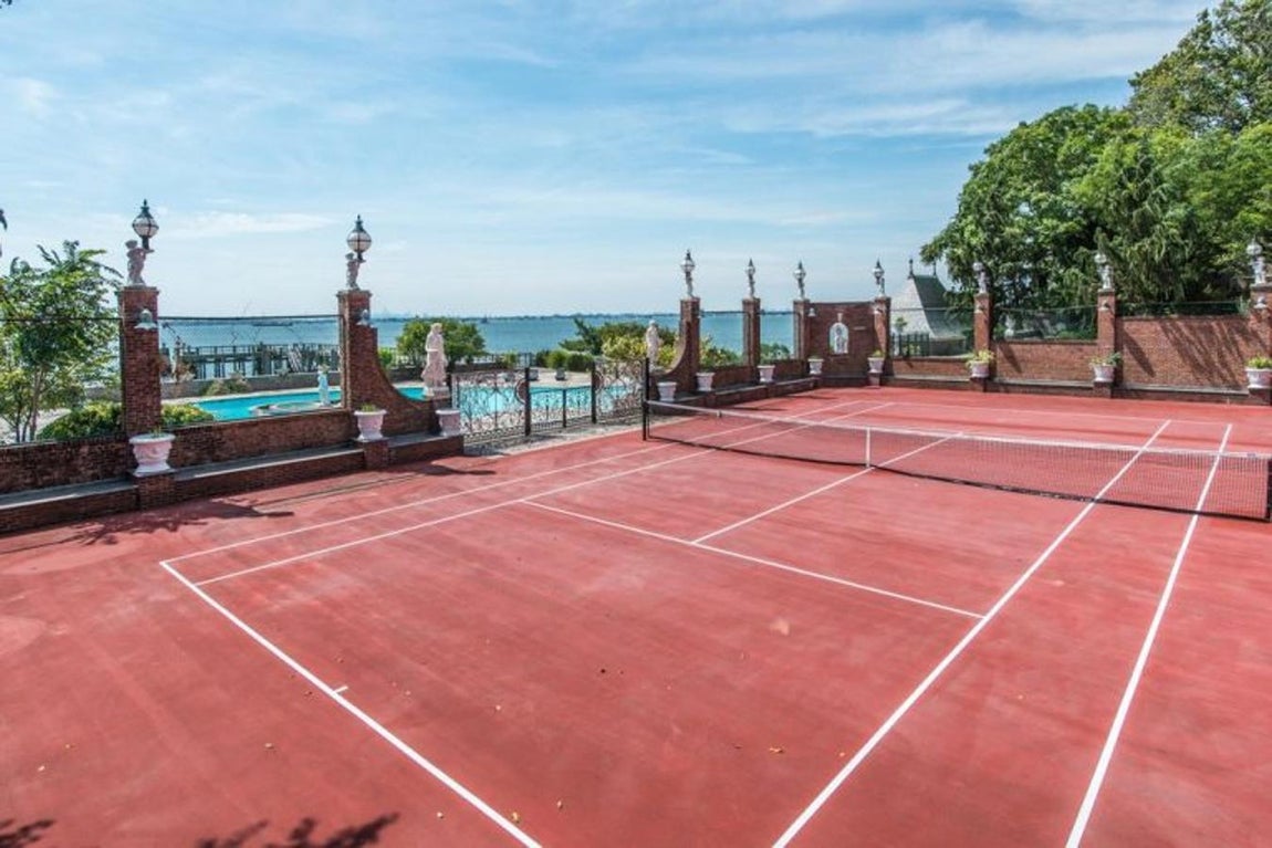 Uno de los accesos a la piscina es desde el campo de tenis.