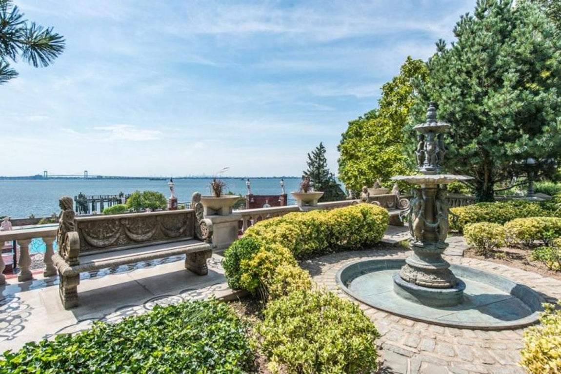 Jardín estilo inglés con banco de piedra.