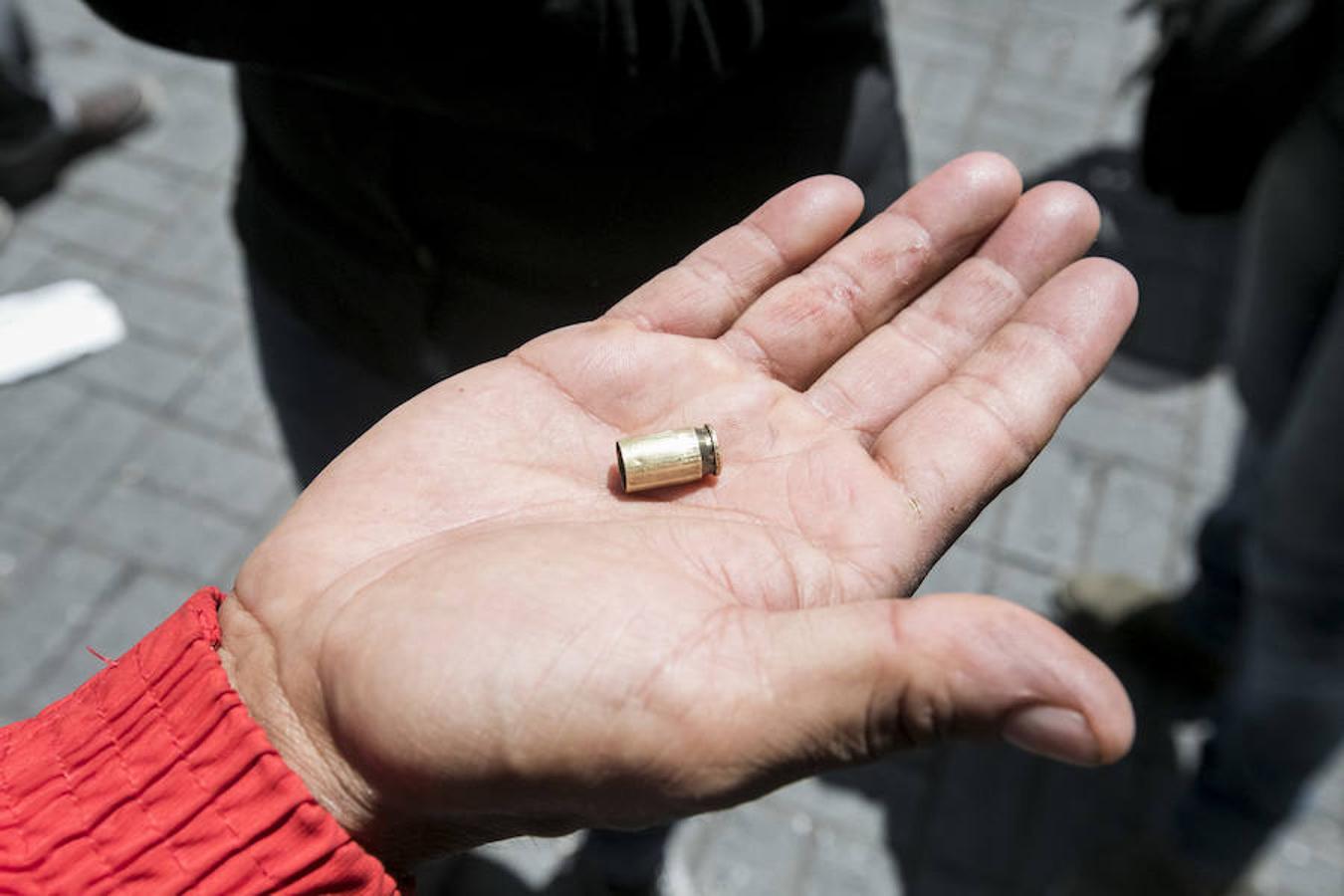 Un simpatizante del Gobierno muestra un casquillo de bala luego de enfrentamientos en la Asamblea Nacional.