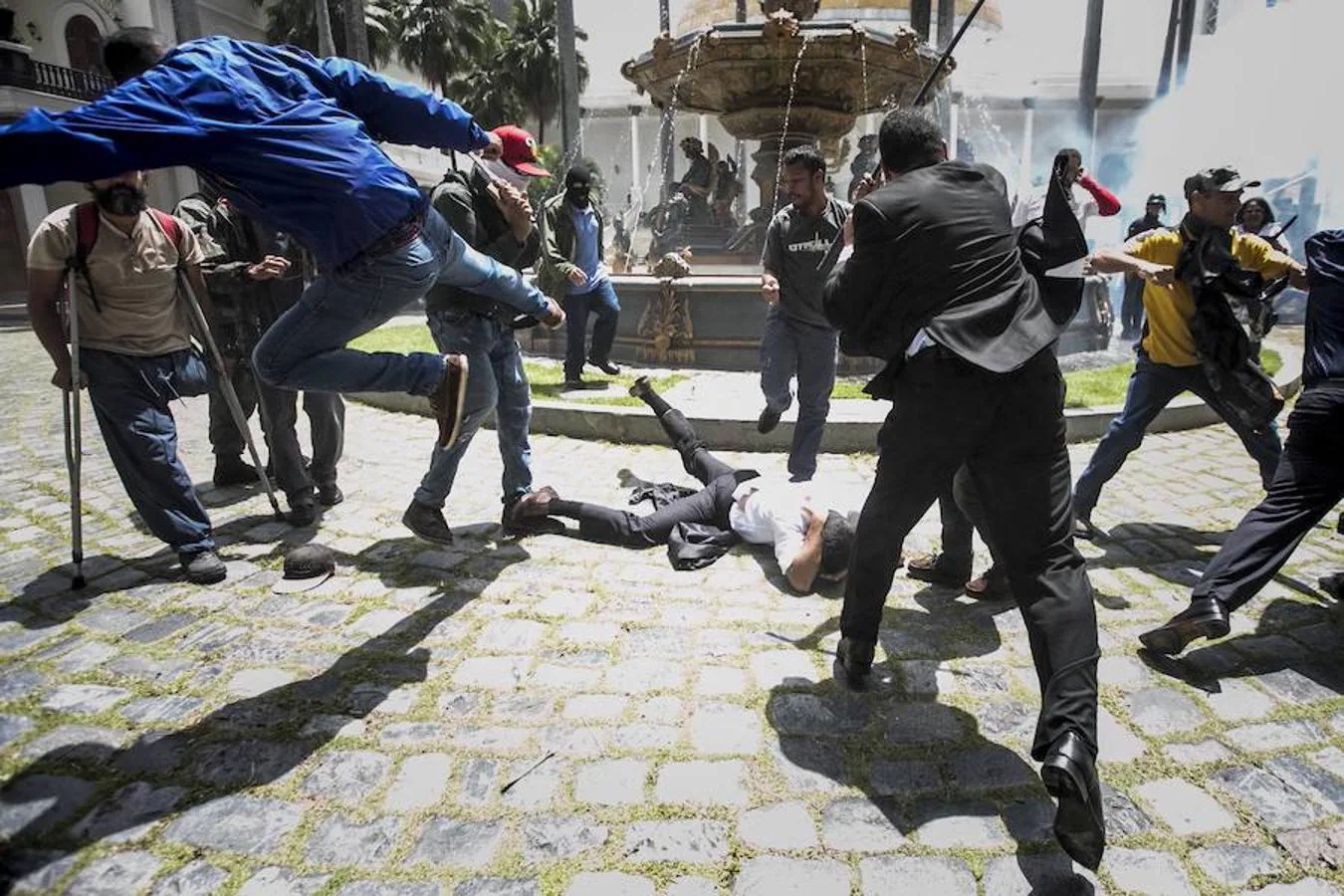 El diputado Armando Armas es golpeado por manifestantes en el suelo en la Asamblea Nacional.