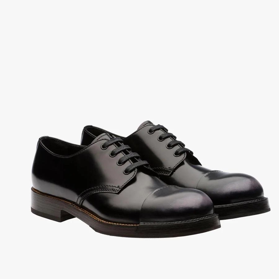 Zapatos derby con cordones en piel de becerro negra y puntera envejecida (475 €).