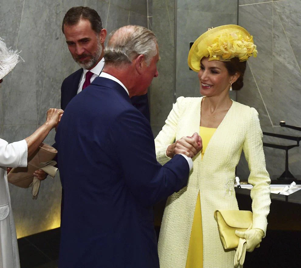La Reina se ha decantado por un vestido seda cady limón complementado con cartera y guantes en el mismo color. 