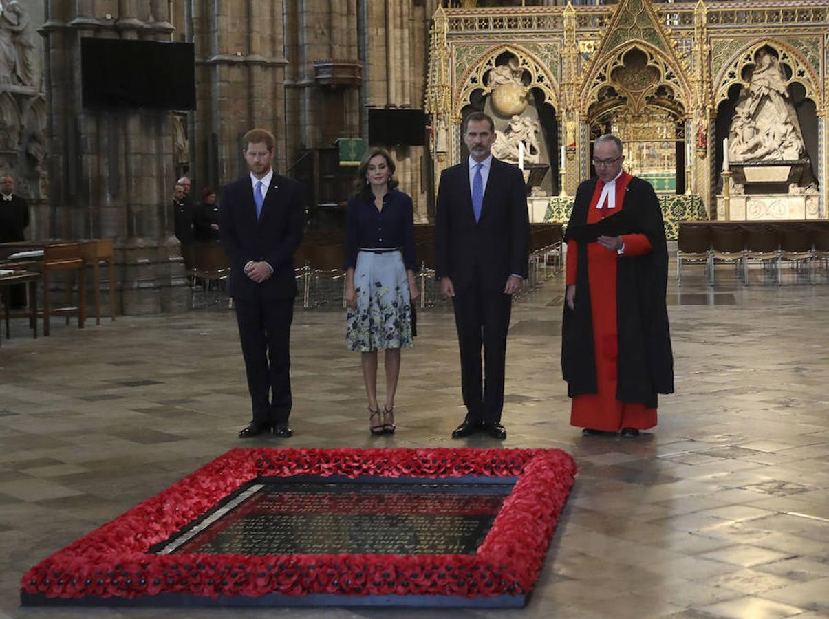 Los reyes Felipe VI y Letizia acompañados por el príncipe Enrique de Gales (i), realizan una ofrenda ante la tumba del soldado desconocido durante su visita hoy a la abadía de Westminster. Efe