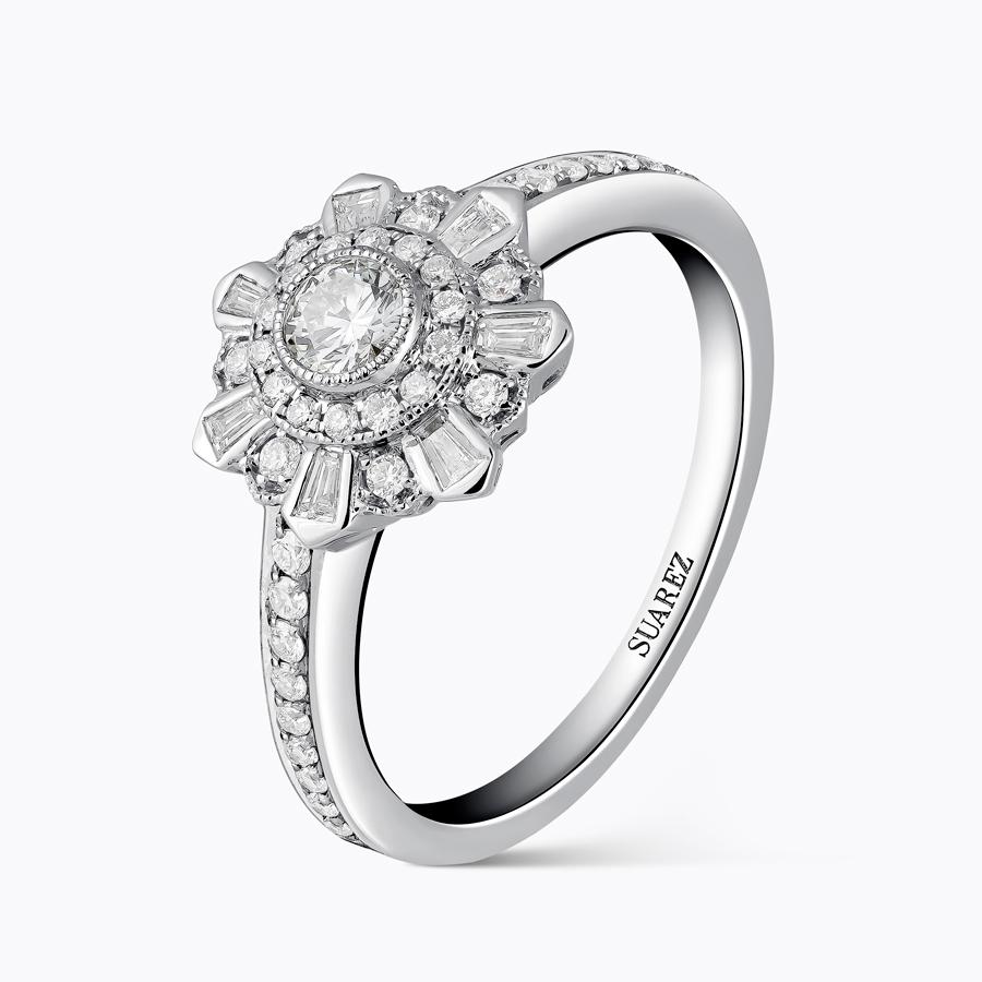 Suárez. Colección Ice Flowers. Sortija de oro blanco con diamante central talla brillante y baguettes tallados y custodiado con brazos de diamantes talla brillante.