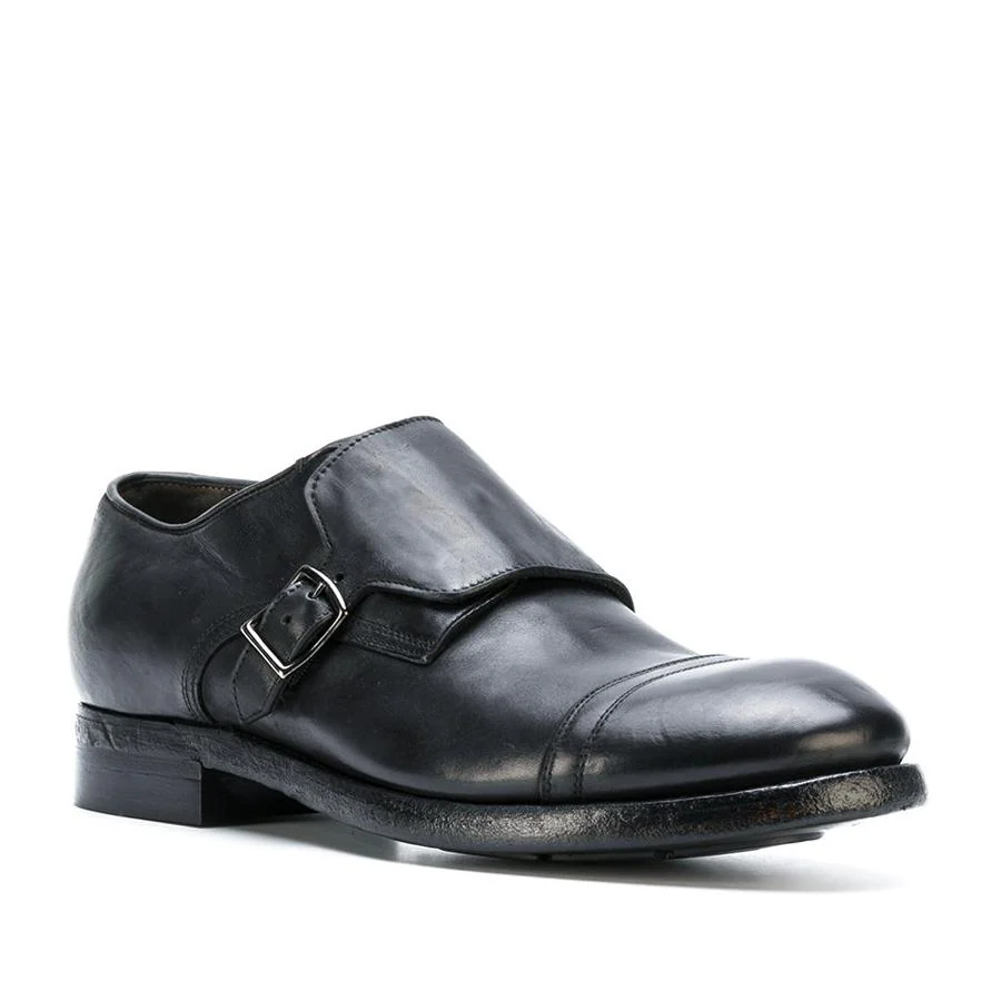 Zapatos monk en piel negros con efecto envejecido (509 €).