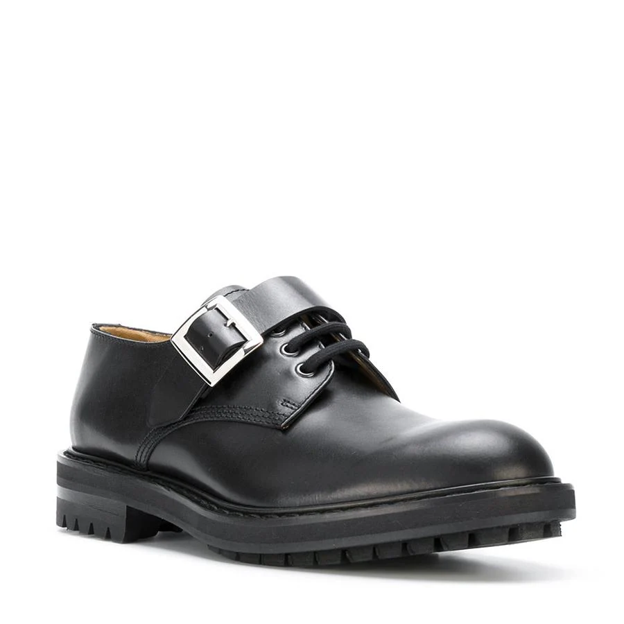 Zapatos derby en piel de becerro negros con hebilla plateada y suela de goma gruesa (720 €).