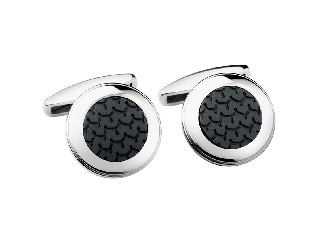 Acero y caucho racing. Con sus armoniosas proporciones y una novedosa mezcla de materiales, estos gemelos Mille Miglia –de la que Chopard es patrocinador- de acero con incrustaciones de caucho rinden un tributo, sobrio y elegante, al universo de las carreras automovilísticas. Estos lujosos gemelos, realzados por la mezcla del brillo del acero y la suavidad mate del caucho, lucen un diseño de neumático Dunlop y poseen todo el estilo del diseño automovilístico.