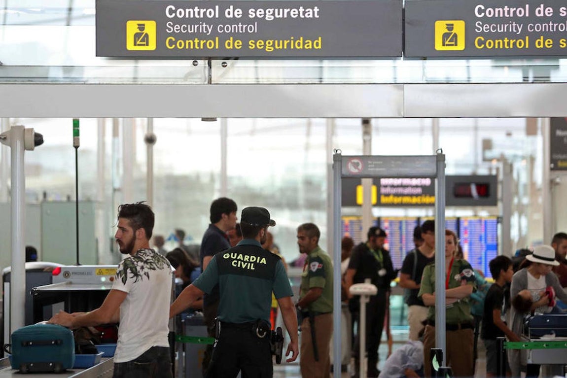 La Guardia Civil custodian los accesos a las puertas de embarque en el aeropuerto de Barcelona. 